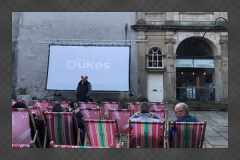 Outdoor sunset film screening in Sun Square Lancaster with projection on the Music Room building