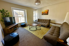 Light and airy living room at The Joseph Cosy with city skyline views and sofa beds