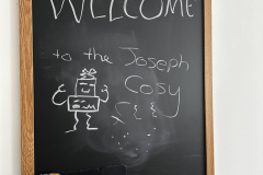 Interactive welcome chalkboard in the kitchen diner at The Joseph Cosy with guest doodles and notes
