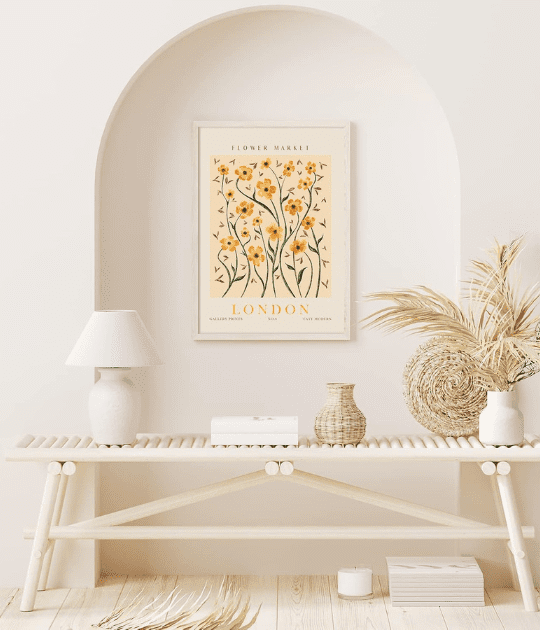 A close-up of a single framed floral print placed above a wooden shelf, styled with a lamp, dried plants, and neutral decor elements, creating a cozy and natural aesthetic.