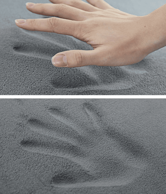 A hand pressing into the memory foam surface, demonstrating its plush texture and the deep imprint it leaves, which slowly bounces back for comfort and support.