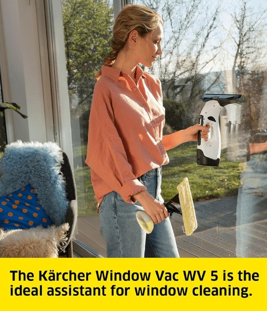A person cleaning a window with the Kärcher Window Vac and spray bottle.