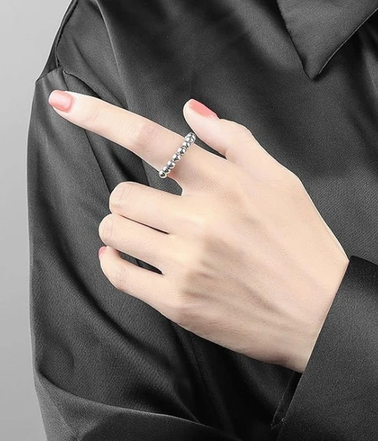 A model wears the silver beaded ring on their index finger, demonstrating its versatile fit and subtle shine, making it a perfect accessory.