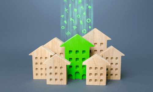 Cluster of small wooden houses with one painted green, illuminated by glowing eco-icons, symbolizing sustainable housing.